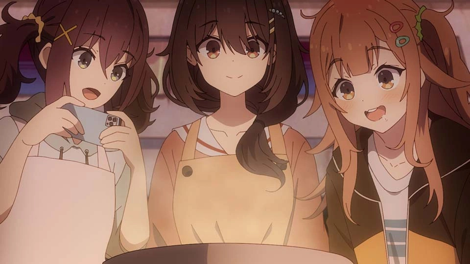 Três personagens de anime, da esquerda para a direita: mulher de cabelos longos em maria-chiquinha, olhos verdes e um celular na mão, uma mulher de cabelos pretos longos e olhos dourados e uma mulher de cabelos castanhos longos e olhos castanhos. Ambas olham felizes para um prato que acabaram de preparar.